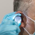 Medical procedure involving ear examination.