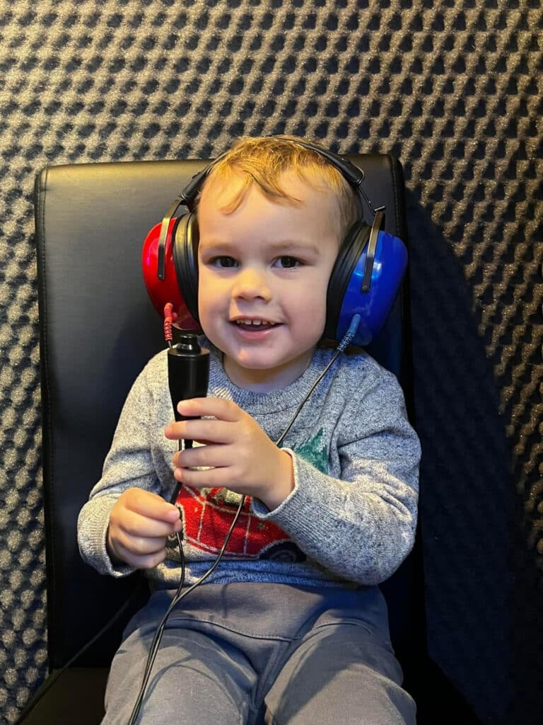 Child wearing ear defenders during hearing test at Wigan Hearing clinic in Standish